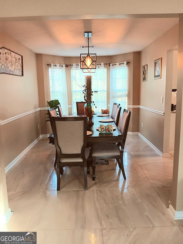 dining space featuring a textured ceiling