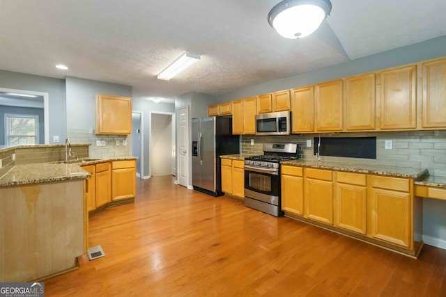 kitchen featuring stainless steel appliances, sink, and backsplash