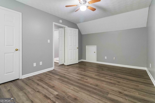 bonus room featuring dark wood-type flooring, ceiling fan, a textured ceiling, and vaulted ceiling