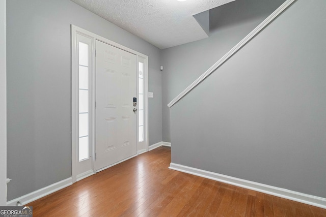 foyer with hardwood / wood-style flooring and a textured ceiling