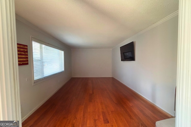 unfurnished room featuring crown molding, a textured ceiling, and wood finished floors