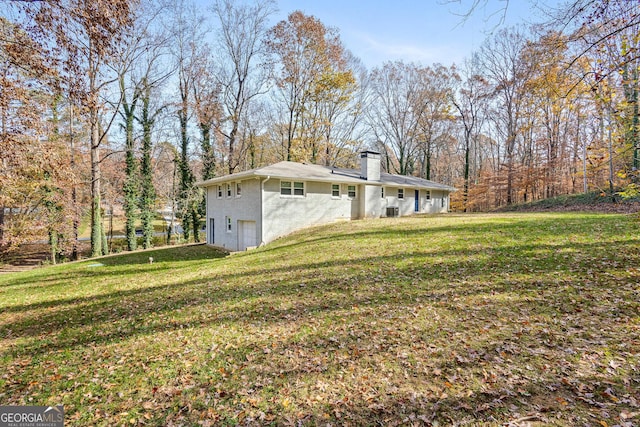 view of side of home with a yard