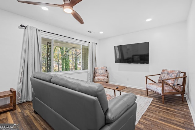 living room featuring ceiling fan and dark hardwood / wood-style flooring