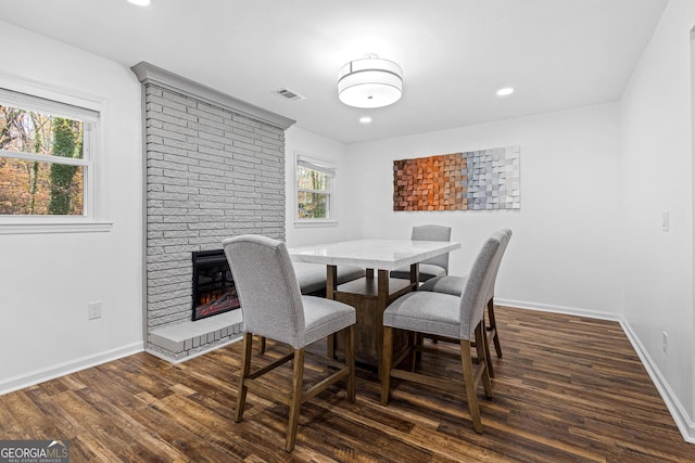 dining room featuring a fireplace and dark hardwood / wood-style flooring