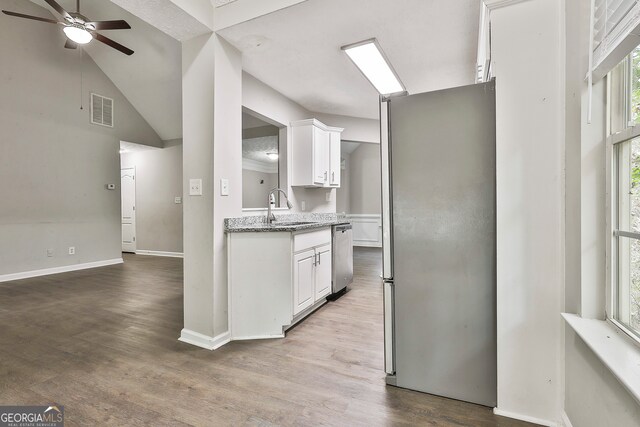 kitchen with white cabinetry, stainless steel appliances, wood-type flooring, and sink