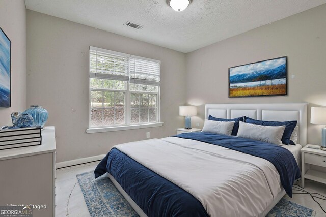 bedroom featuring a textured ceiling, ceiling fan, and a tray ceiling