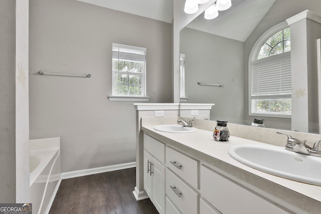 bathroom featuring a bath, vanity, vaulted ceiling, and hardwood / wood-style flooring