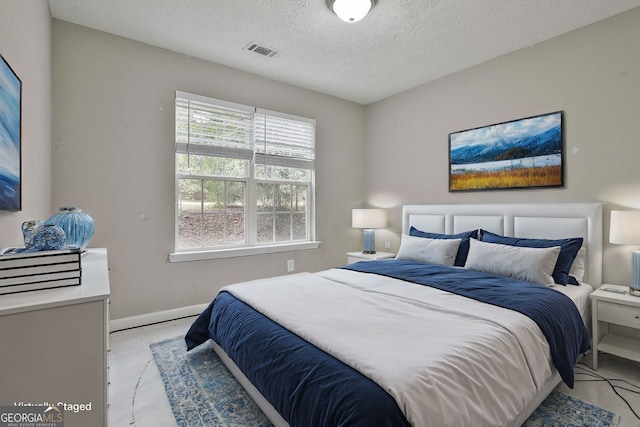 bedroom with a textured ceiling and light hardwood / wood-style flooring