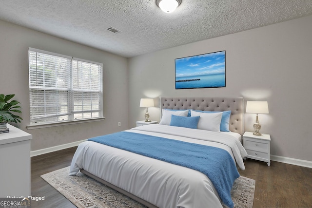 bedroom featuring a textured ceiling and dark hardwood / wood-style floors