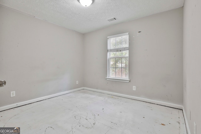 spare room with a textured ceiling