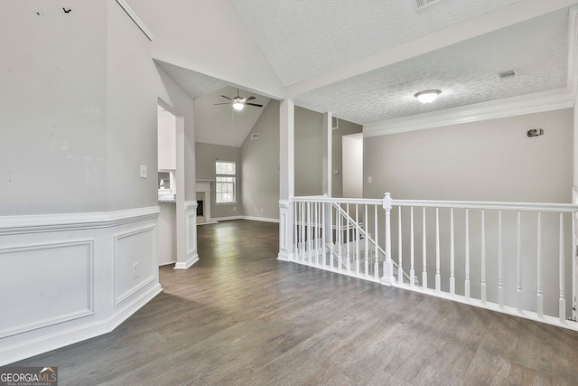 spare room featuring dark hardwood / wood-style flooring, a textured ceiling, ceiling fan, and vaulted ceiling