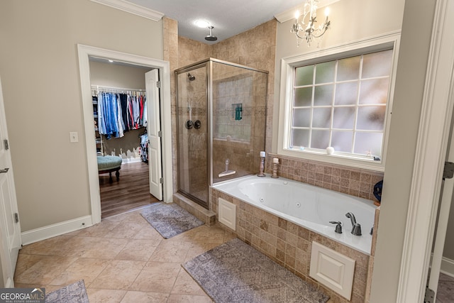 bathroom with tile patterned flooring, ornamental molding, separate shower and tub, and a notable chandelier