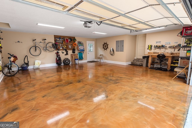 garage featuring a workshop area, electric panel, and a garage door opener