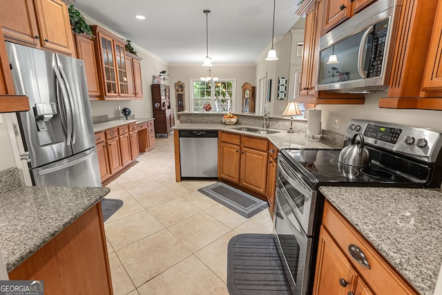 kitchen featuring light stone counters, ornamental molding, appliances with stainless steel finishes, decorative light fixtures, and a notable chandelier