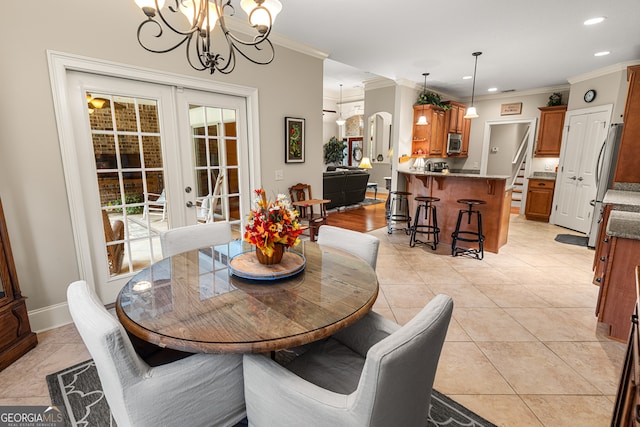 dining room featuring ornamental molding, french doors, a notable chandelier, and light tile patterned floors