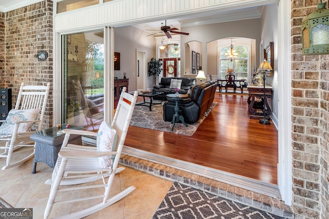 interior space with hardwood / wood-style floors, ceiling fan with notable chandelier, and crown molding