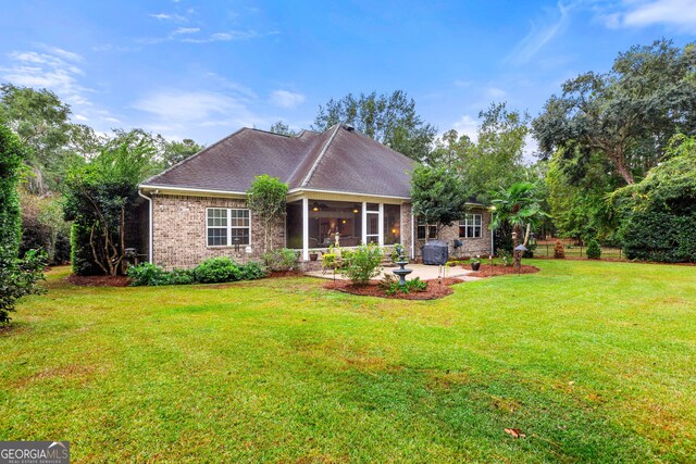 rear view of property with a patio, a sunroom, and a lawn