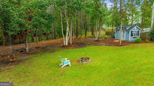 view of yard with an outdoor fire pit and a storage unit