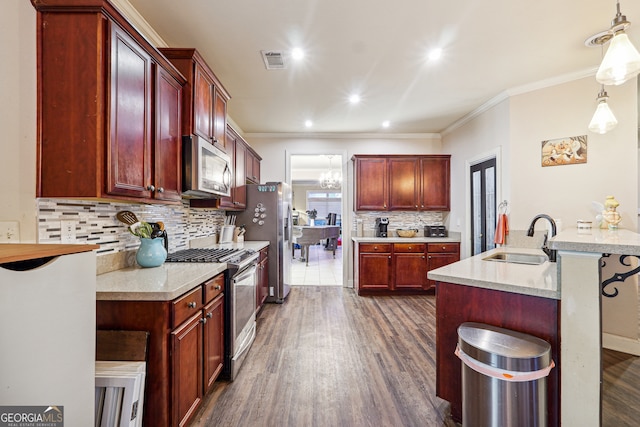 kitchen with decorative light fixtures, appliances with stainless steel finishes, sink, and a kitchen bar