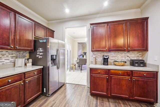 kitchen featuring stainless steel refrigerator with ice dispenser, wood-type flooring, decorative backsplash, and crown molding