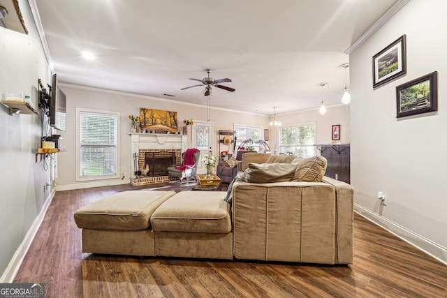 living room featuring ceiling fan, dark hardwood / wood-style floors, crown molding, and a brick fireplace