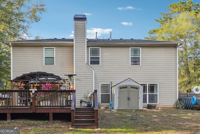 back of property with a wooden deck, a storage shed, and a gazebo