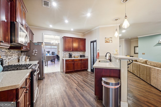 kitchen with sink, appliances with stainless steel finishes, crown molding, dark wood-type flooring, and pendant lighting