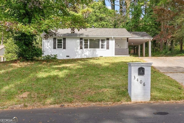 view of front of home with a front yard and a carport