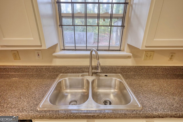 details featuring white cabinets and sink