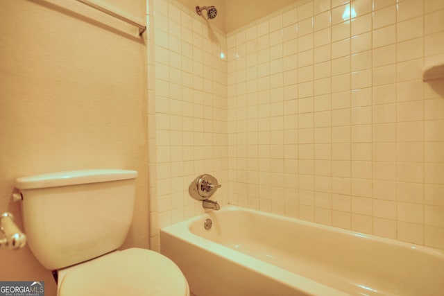 bathroom featuring tiled shower / bath and toilet