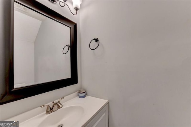 bathroom with vanity and lofted ceiling