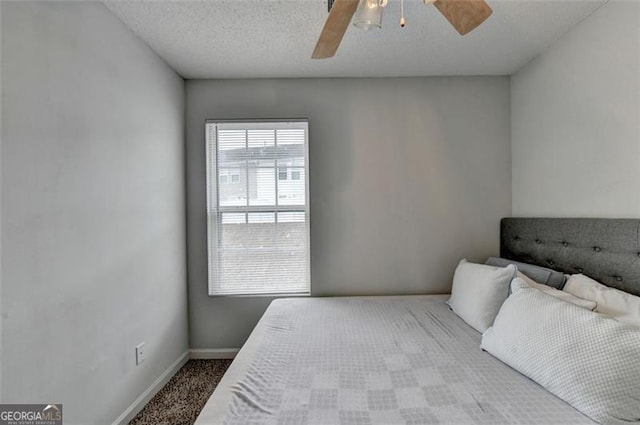 bedroom with ceiling fan, a textured ceiling, and carpet