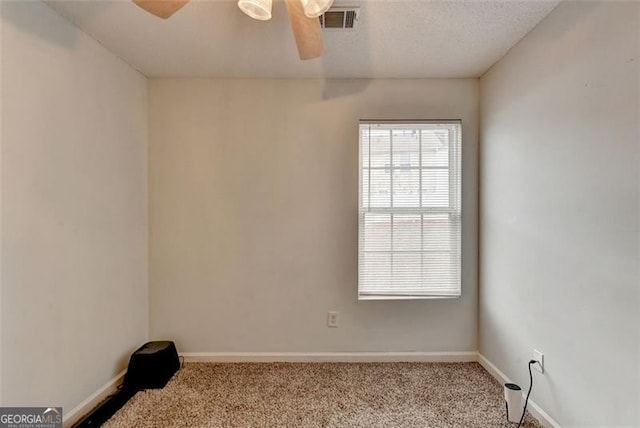 unfurnished room with a textured ceiling, light colored carpet, and ceiling fan