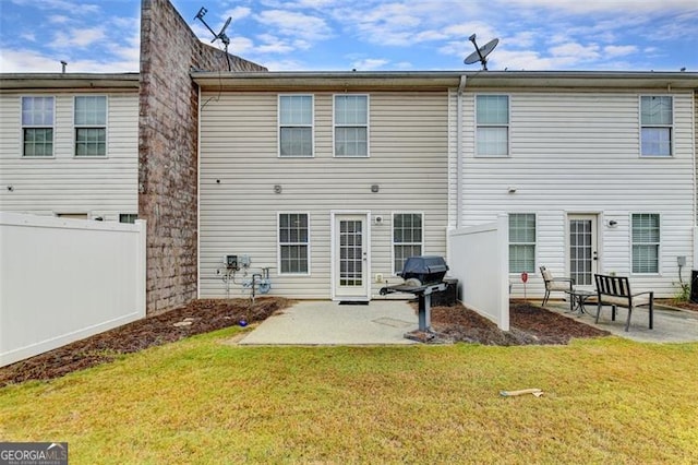 back of house featuring a lawn and a patio