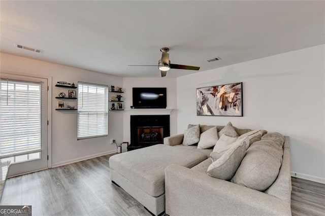 living room featuring wood-type flooring and ceiling fan