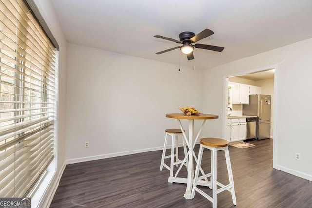 dining space with dark hardwood / wood-style flooring, ceiling fan, and sink