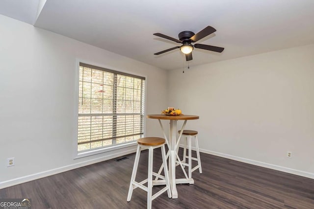 dining area with ceiling fan and dark wood-type flooring