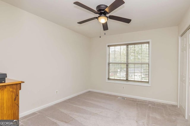 unfurnished bedroom featuring light carpet, a closet, and ceiling fan