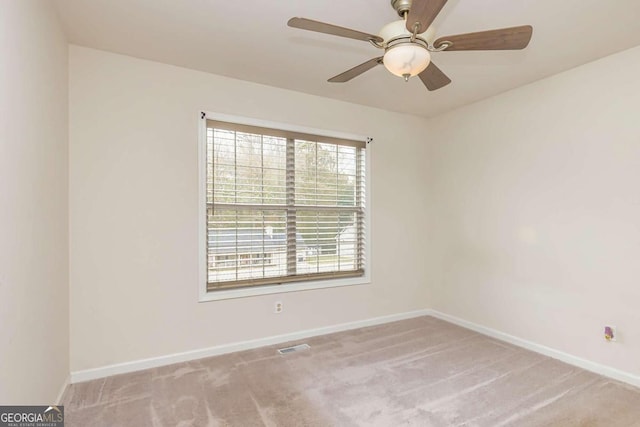 carpeted spare room featuring ceiling fan