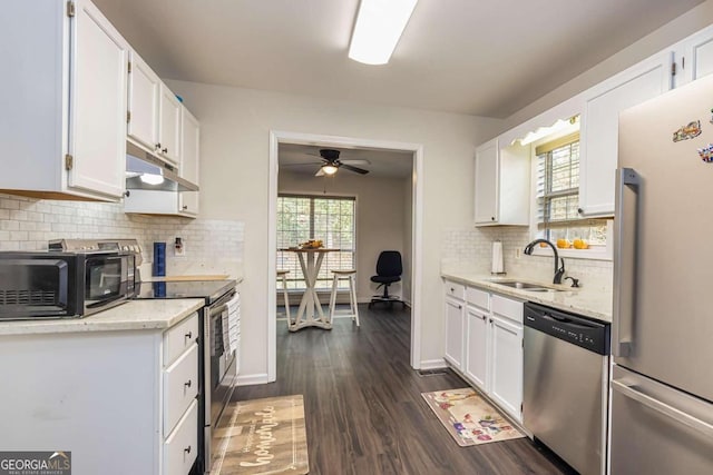 kitchen featuring sink, decorative backsplash, appliances with stainless steel finishes, dark hardwood / wood-style flooring, and white cabinetry