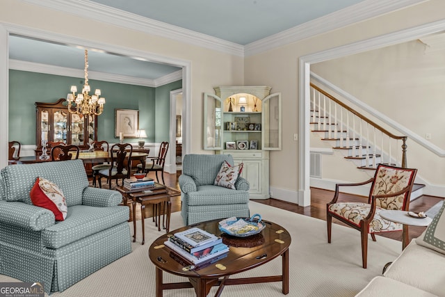 living room with a notable chandelier, crown molding, and wood-type flooring