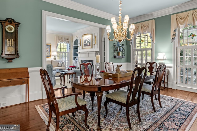 dining area featuring an inviting chandelier, ornamental molding, and wood-type flooring