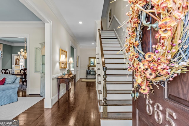 foyer with dark wood-type flooring, recessed lighting, an inviting chandelier, crown molding, and stairs