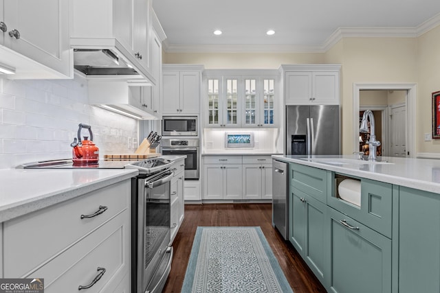 kitchen featuring white cabinetry, tasteful backsplash, stainless steel appliances, and green cabinets