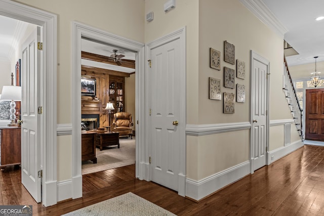 hall with beam ceiling, ornamental molding, and dark hardwood / wood-style flooring