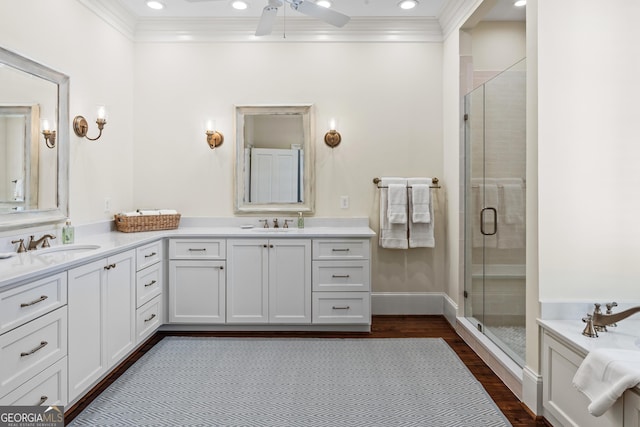 bathroom with walk in shower, crown molding, wood-type flooring, vanity, and ceiling fan