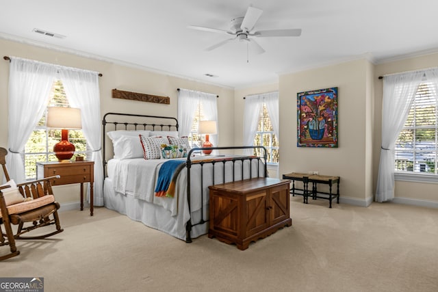 bedroom featuring ornamental molding, light colored carpet, and ceiling fan