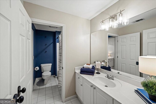 bathroom with tile patterned flooring, vanity, and toilet