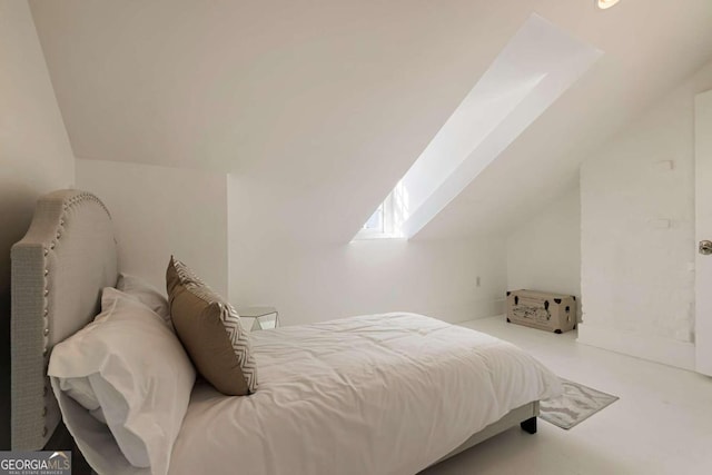 carpeted bedroom featuring lofted ceiling with skylight