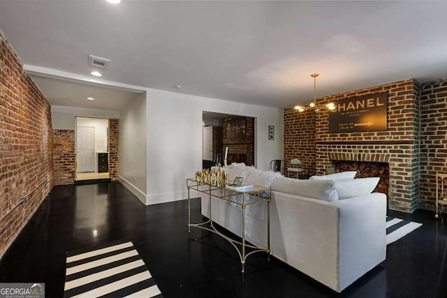 living room with a fireplace, a chandelier, and brick wall